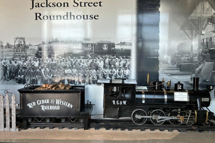 Model train display at Jackson Street Roundhouse with vintage photo backdrop.