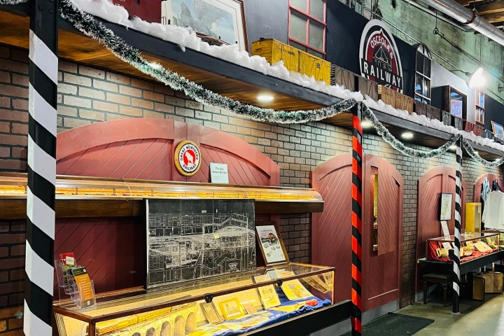 Museum display with railway artifacts, brick wall, snow decor, and Osceola Railway sign.