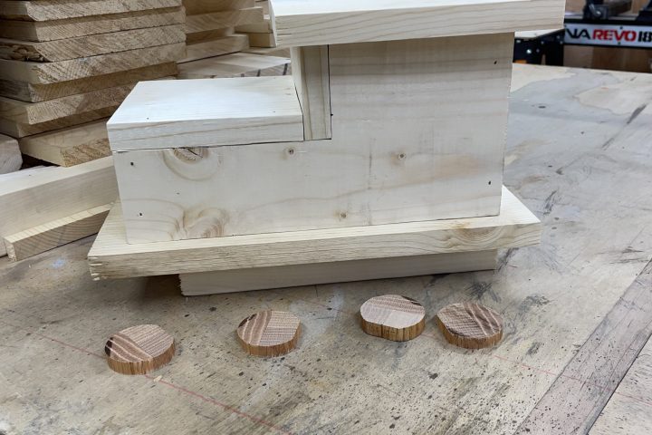 Wooden pieces and cutouts arranged on a workshop table.